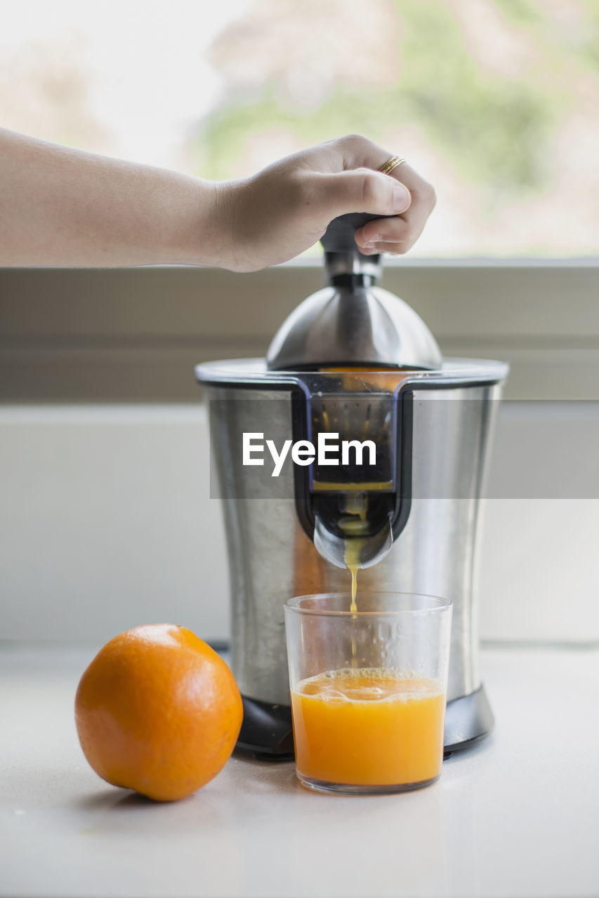 Close-up of hand doing orange juice