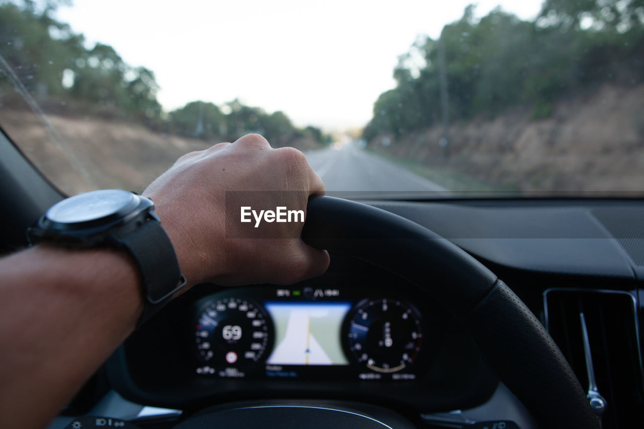 Cropped hand of man driving car