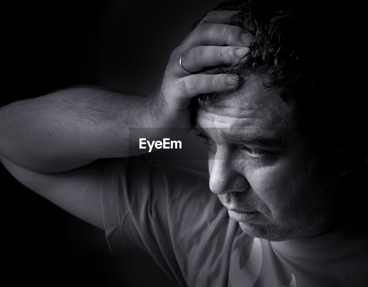 Close-up depressed man against black background