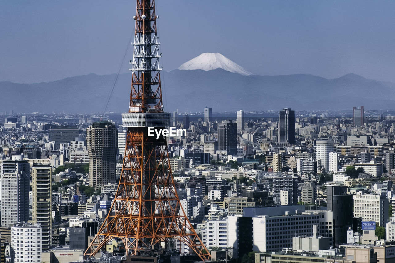 Tokyo tower amidst buildings against sky in city
