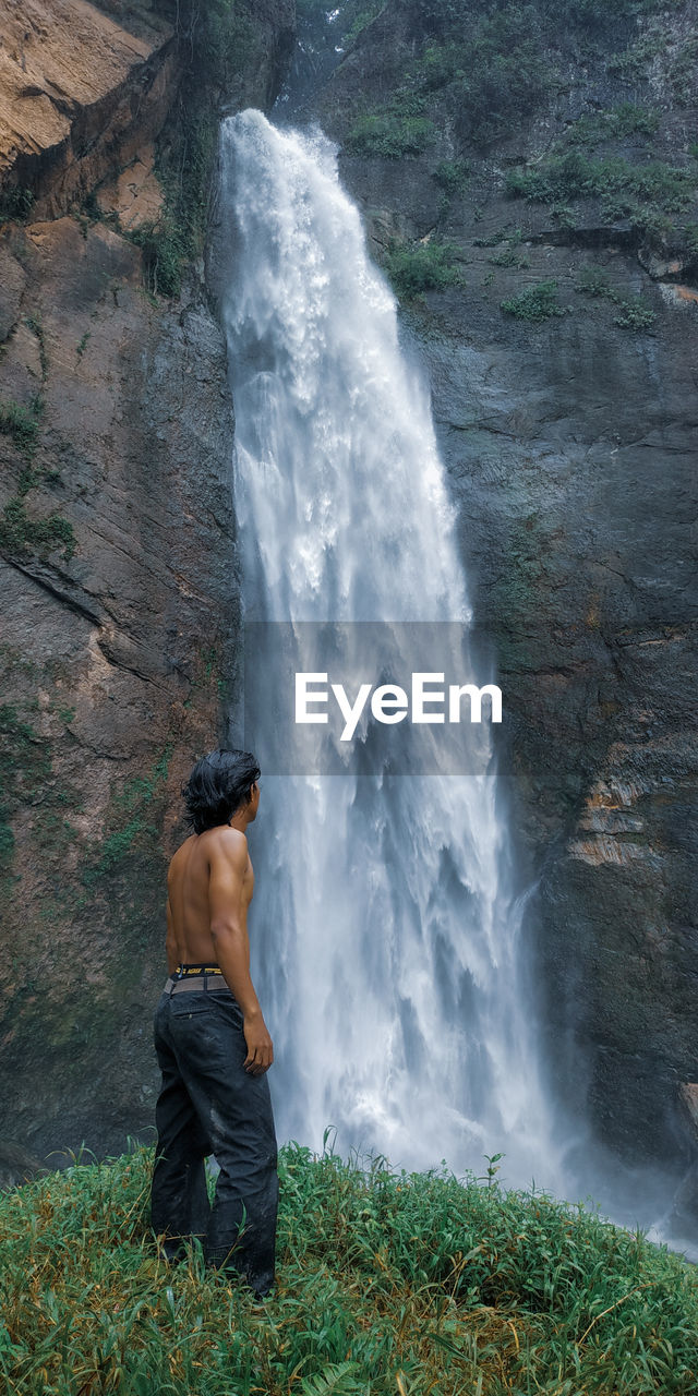 Full length of shirtless man standing in water