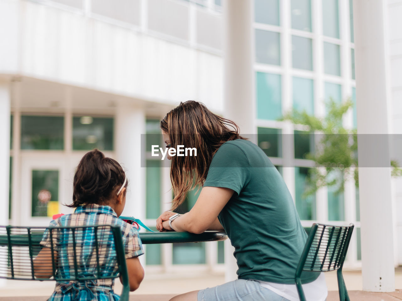 Young millennial mother sending daughter off back to school