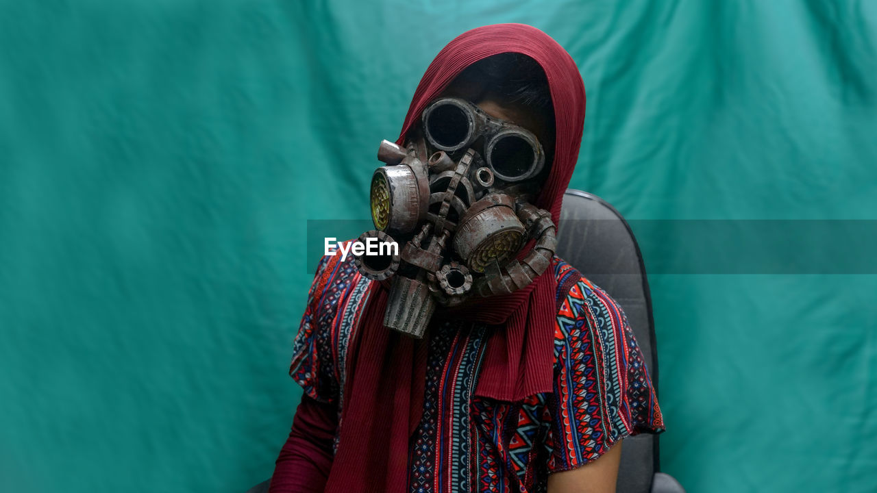 Portrait of man wearing hat and gas mask