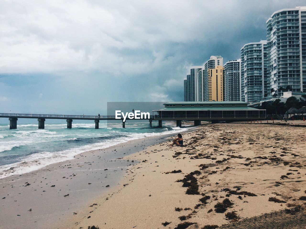 Scenic view of beach by city against sky