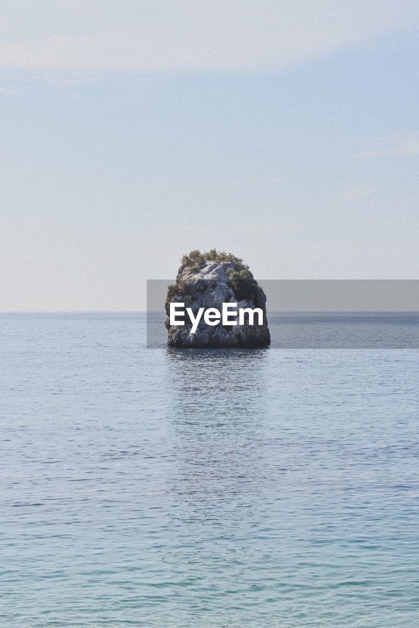 Scenic view of rocks in sea against sky