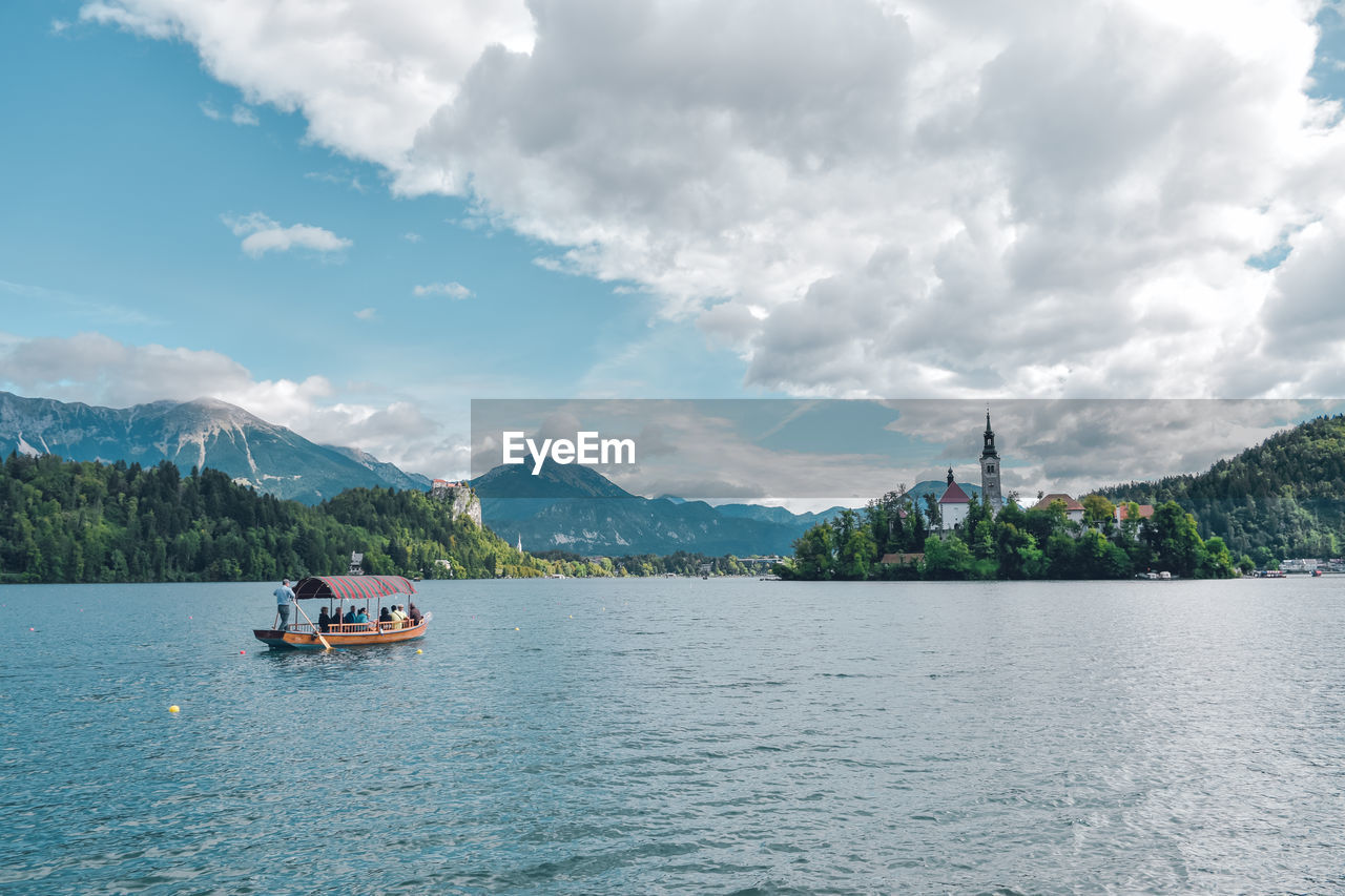 Scenic view of boats in lake against cloudy sky