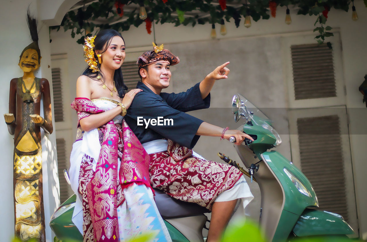 Portrait of a traditional balinese couple on a motorbike 