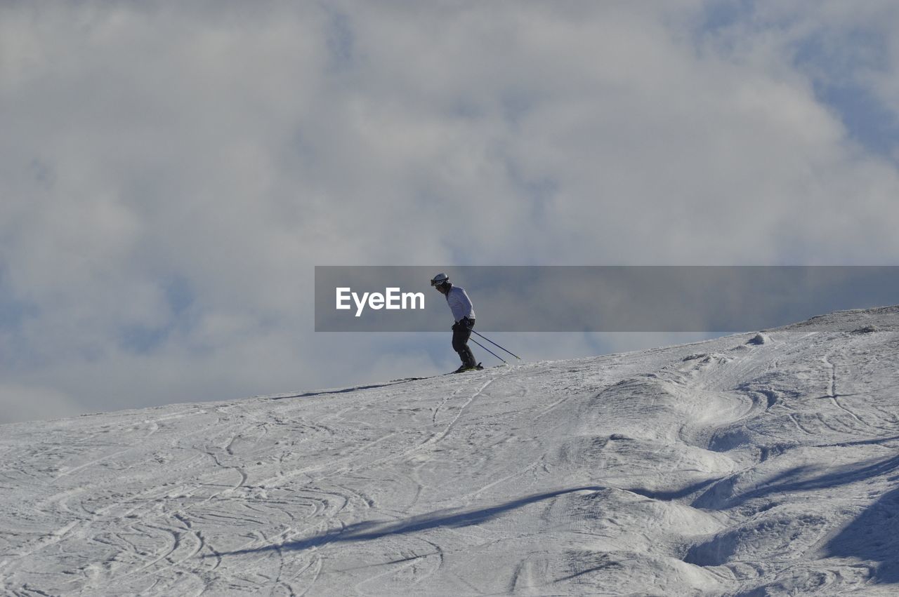 Man on snowcapped mountain against sky