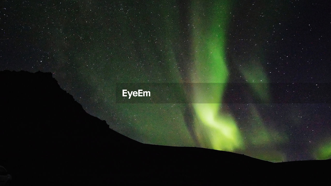 Low angle view of silhouette mountain against sky at night