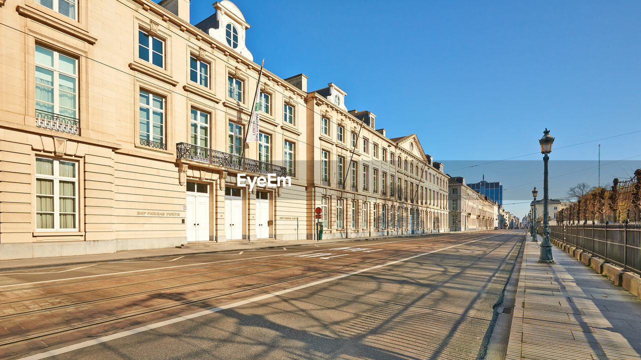 STREET AMIDST BUILDINGS AGAINST CLEAR SKY