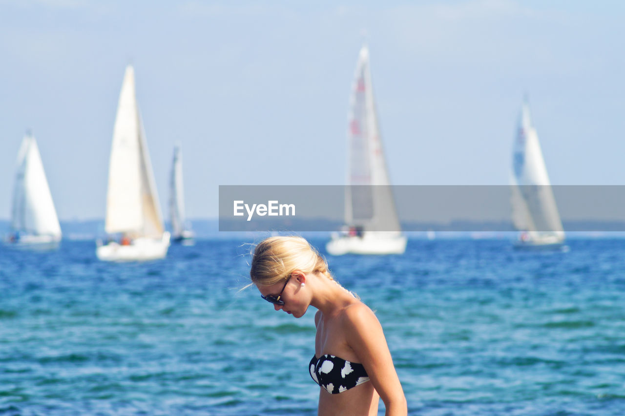 Woman wearing bikini top against sea