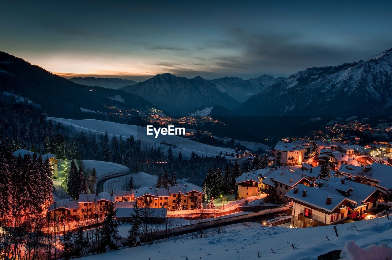 Illuminated buildings against sky during winter at night