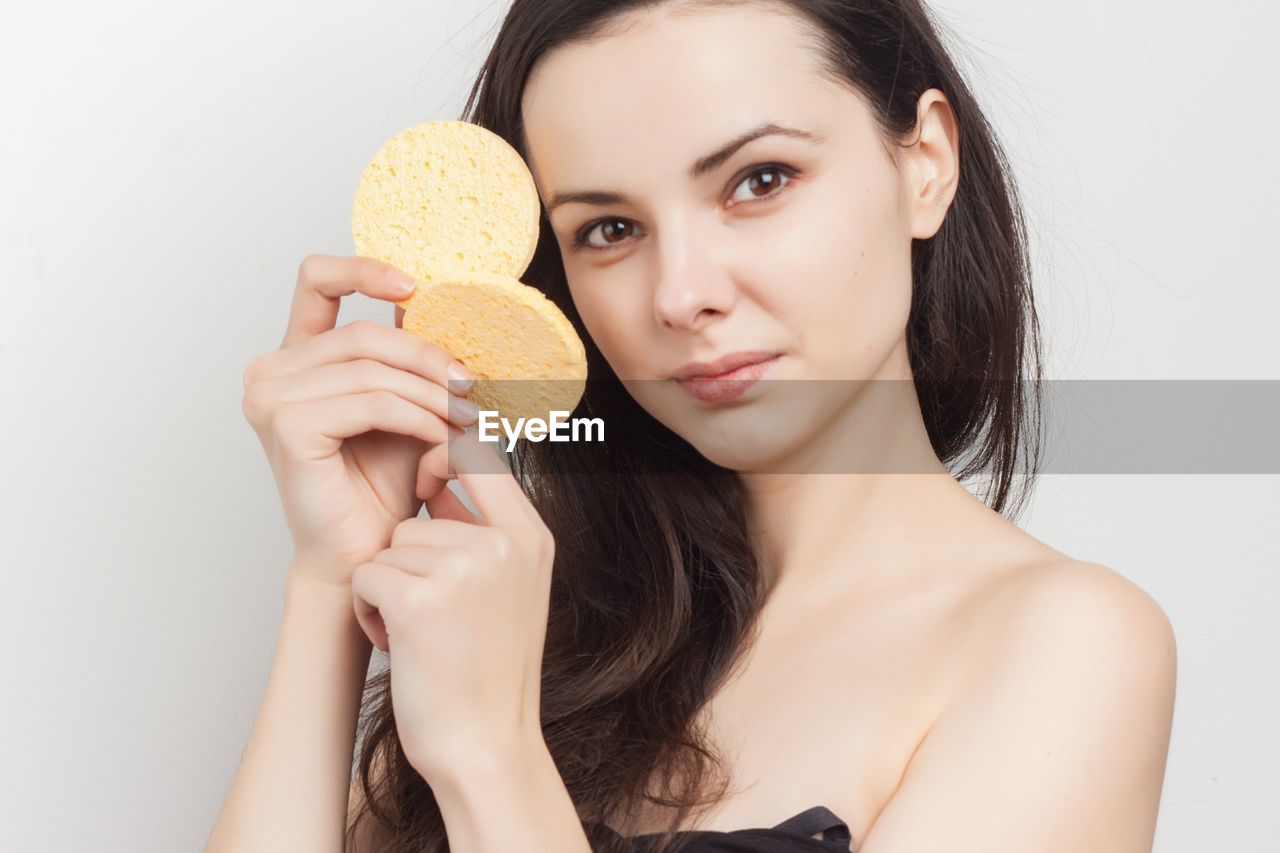 women, one person, portrait, food, skin, young adult, studio shot, adult, food and drink, holding, indoors, human face, headshot, wellbeing, long hair, freshness, white background, hairstyle, human hair, human head, smiling, looking at camera, nose, brown hair, photo shoot, healthy eating, fruit, person, front view, eating, finger, hand, happiness, sweet food, female, lifestyles, make-up, black hair, cut out, fashion, human mouth, waist up, body care, cute, close-up, sweet, emotion