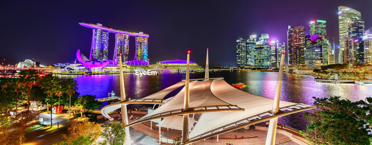 ILLUMINATED MODERN BUILDING BY RIVER AT NIGHT