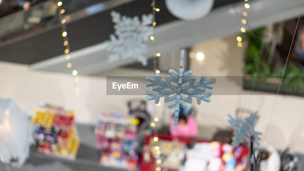 CLOSE-UP OF CHRISTMAS DECORATIONS HANGING IN SHOP