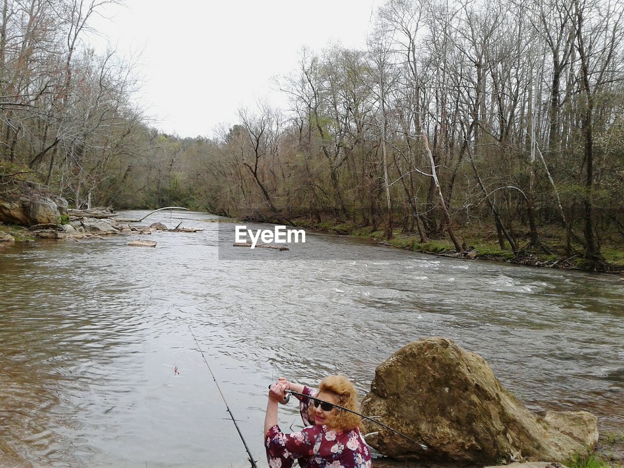 PEOPLE ON RIVERBANK IN FOREST