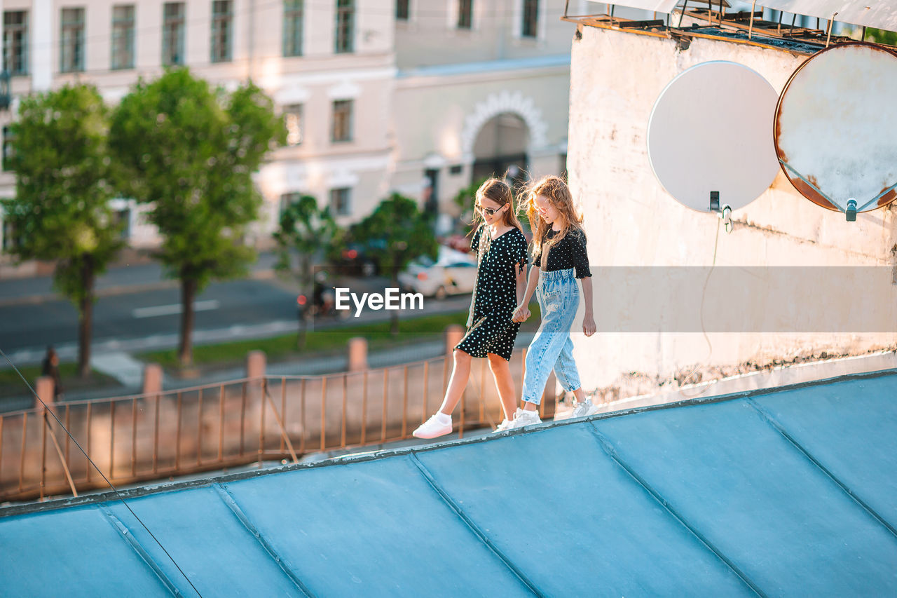 WOMAN BY SWIMMING POOL IN FRONT OF BUILDING