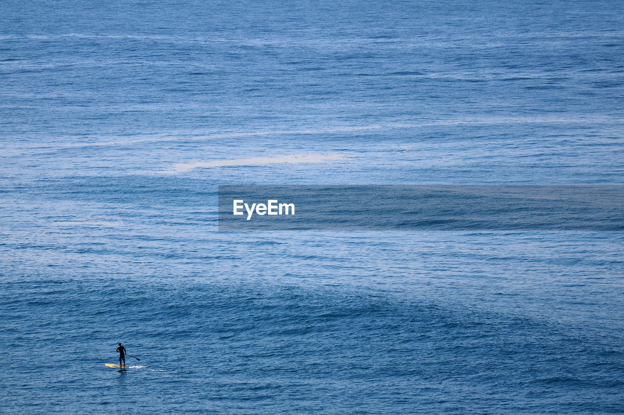 Atlantic ocean with man on paddleboard, copacabana beach, rio de janeiro, brazil