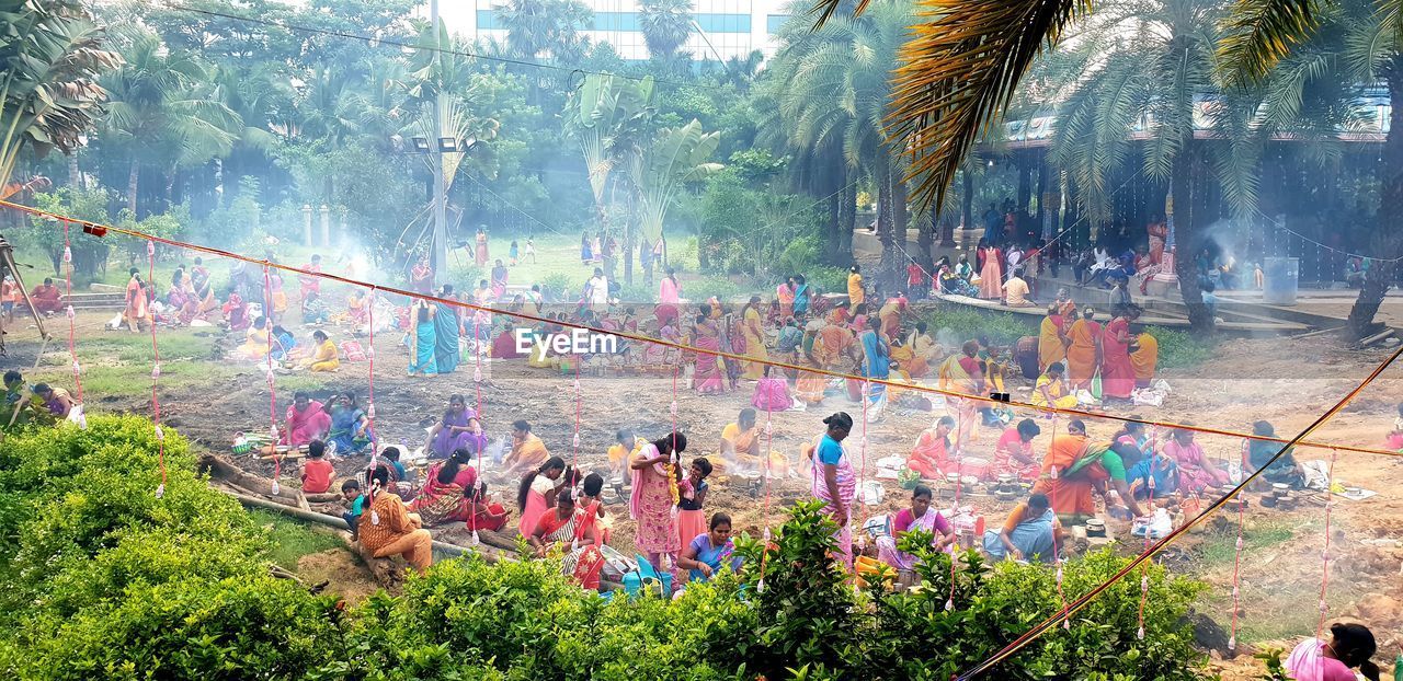 HIGH ANGLE VIEW OF GROUP OF PEOPLE AGAINST PLANTS