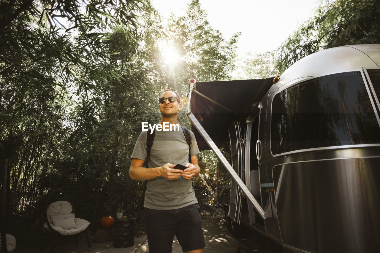 Smiling man walking by motor home