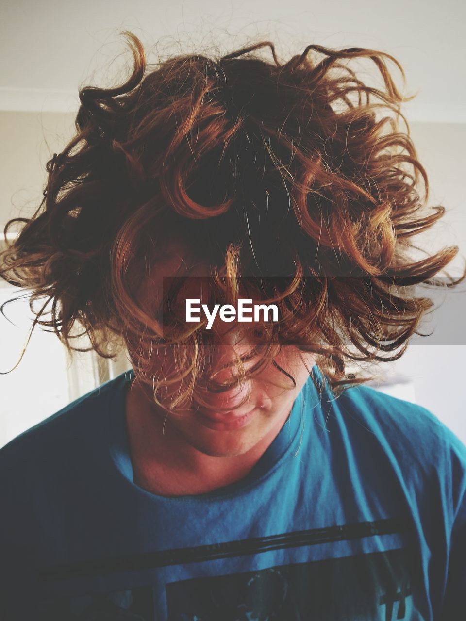 Close-up of young man with tousled hair at home