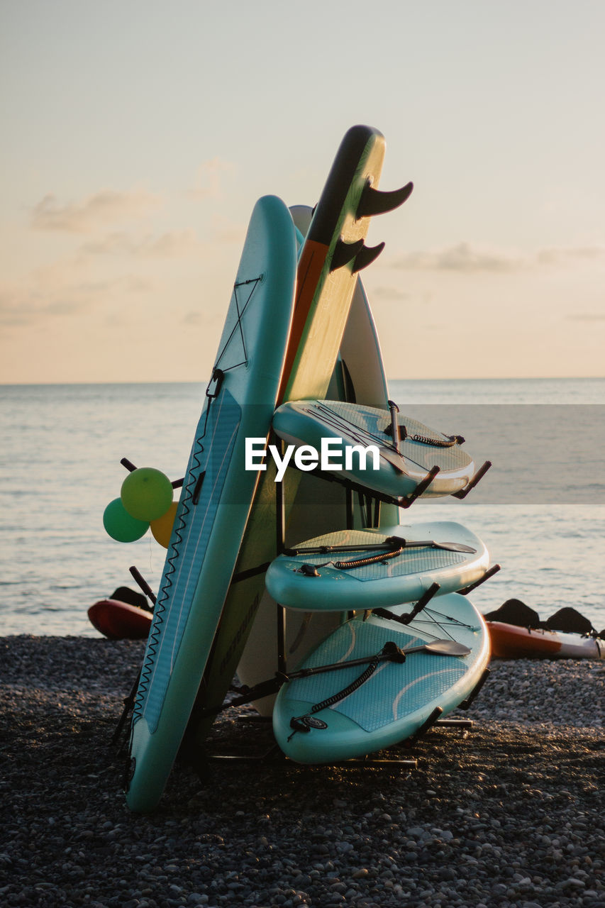 sea, water, sky, beach, land, nature, vehicle, horizon over water, horizon, blue, sand, surfing equipment, tranquility, surfboard, sunset, beauty in nature, tranquil scene, no people, scenics - nature, transportation, nautical vessel, vacation, travel, holiday, trip, outdoors, ocean, day, idyllic, sunlight, relaxation
