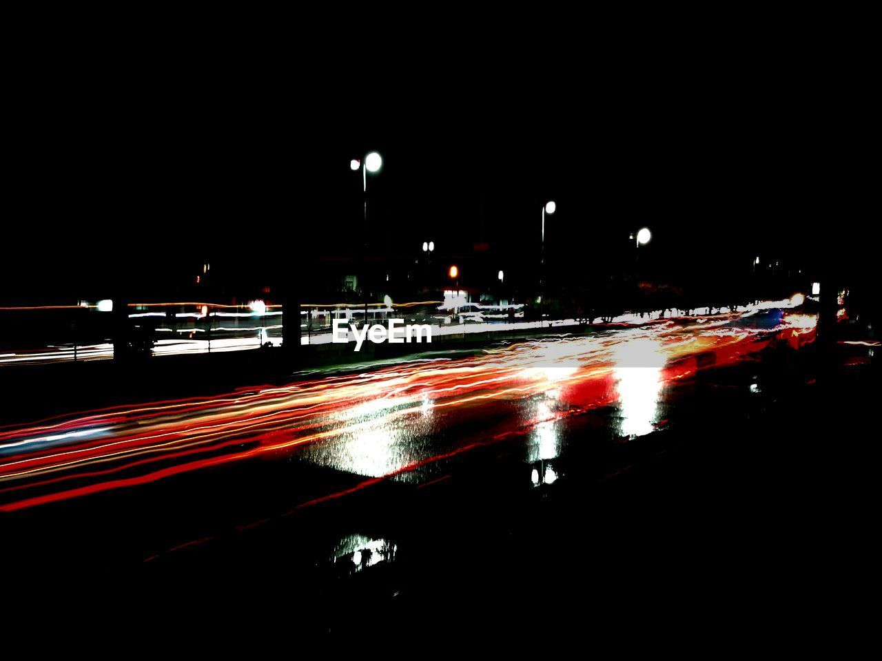 LIGHT TRAILS ON STREET AT NIGHT