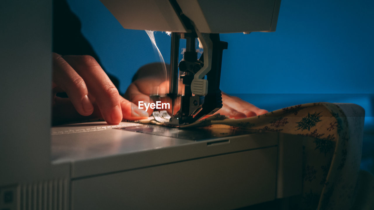 Close-up of man working on sewing machine