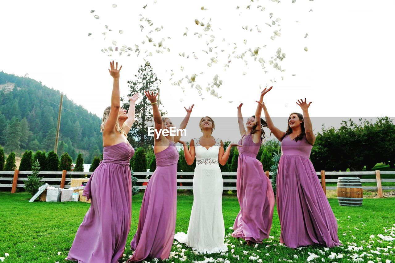 GROUP OF PEOPLE DANCING ON GRASS