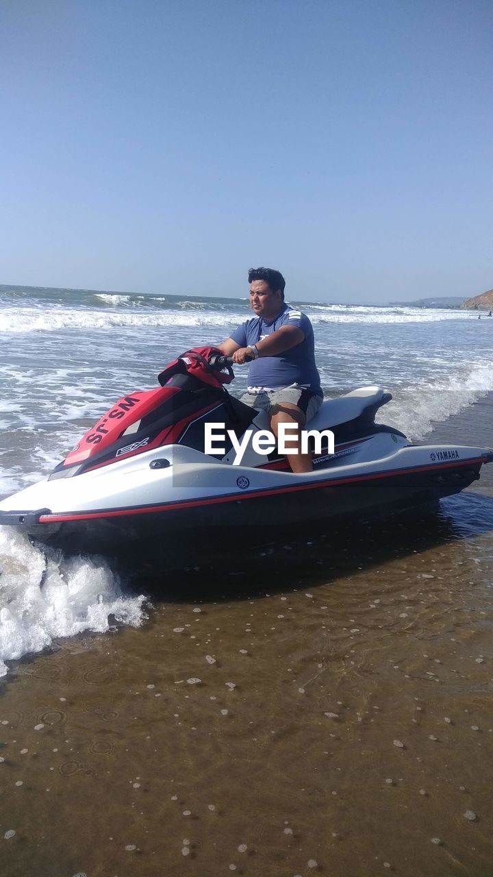 MAN ON BOAT AGAINST SKY