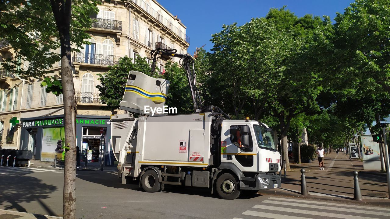 VEHICLES ON ROAD BY BUILDINGS IN CITY