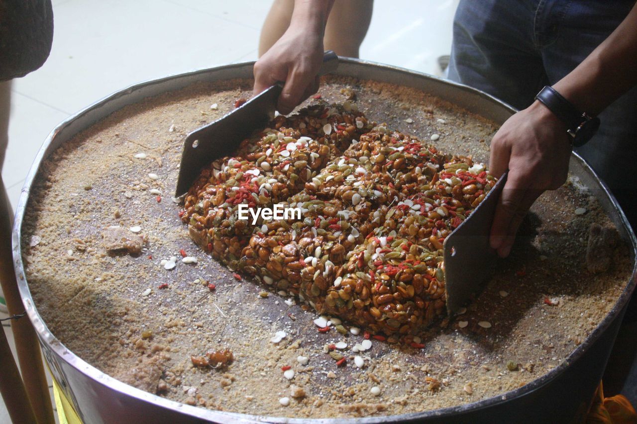 CLOSE-UP OF PERSON PREPARING FOOD IN TRAY