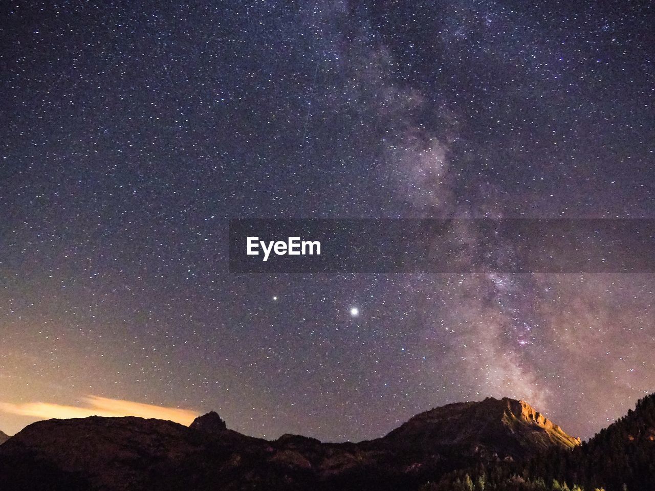 Scenic view of mountains against star field at night