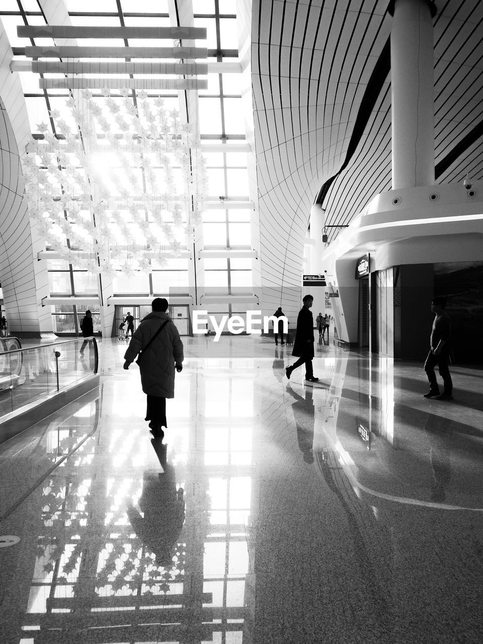 PEOPLE WALKING IN AIRPORT BUILDING