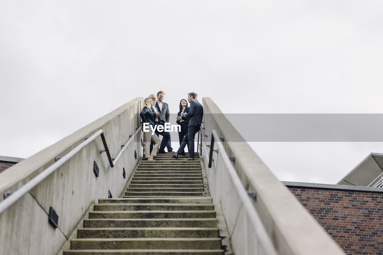 Business people standing on exterior stair