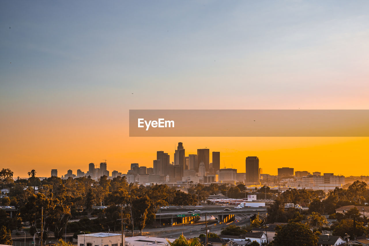 Buildings in city during sunset