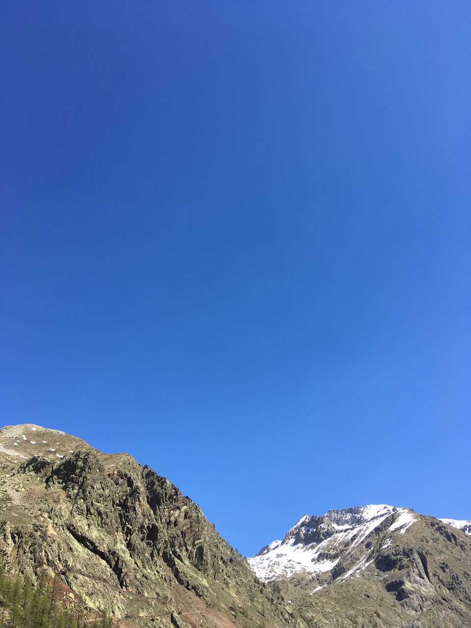 LOW ANGLE VIEW OF MOUNTAIN AGAINST BLUE SKY