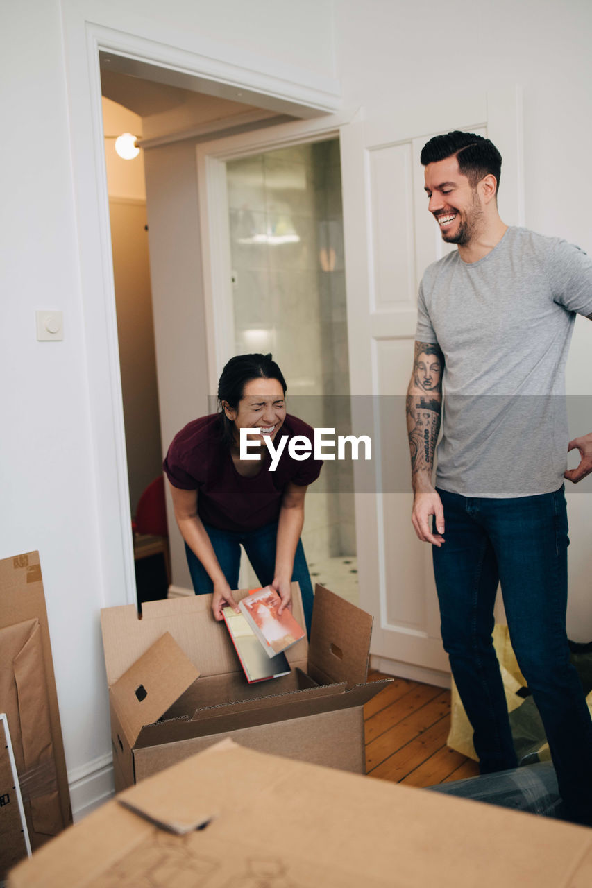 Couple enjoying while unpacking boxes in new apartment