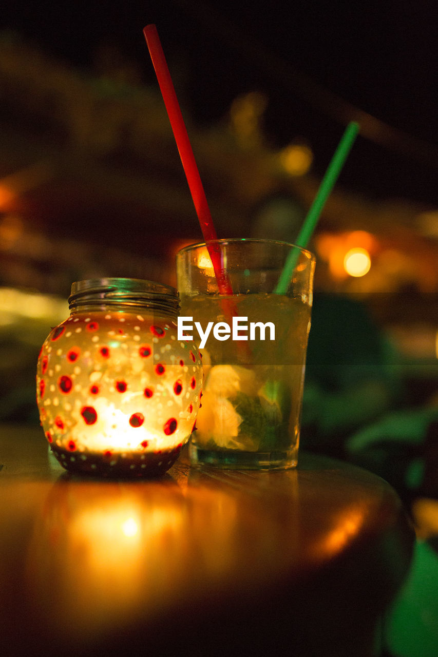 CLOSE-UP OF BEER GLASS ON TABLE AT NIGHT