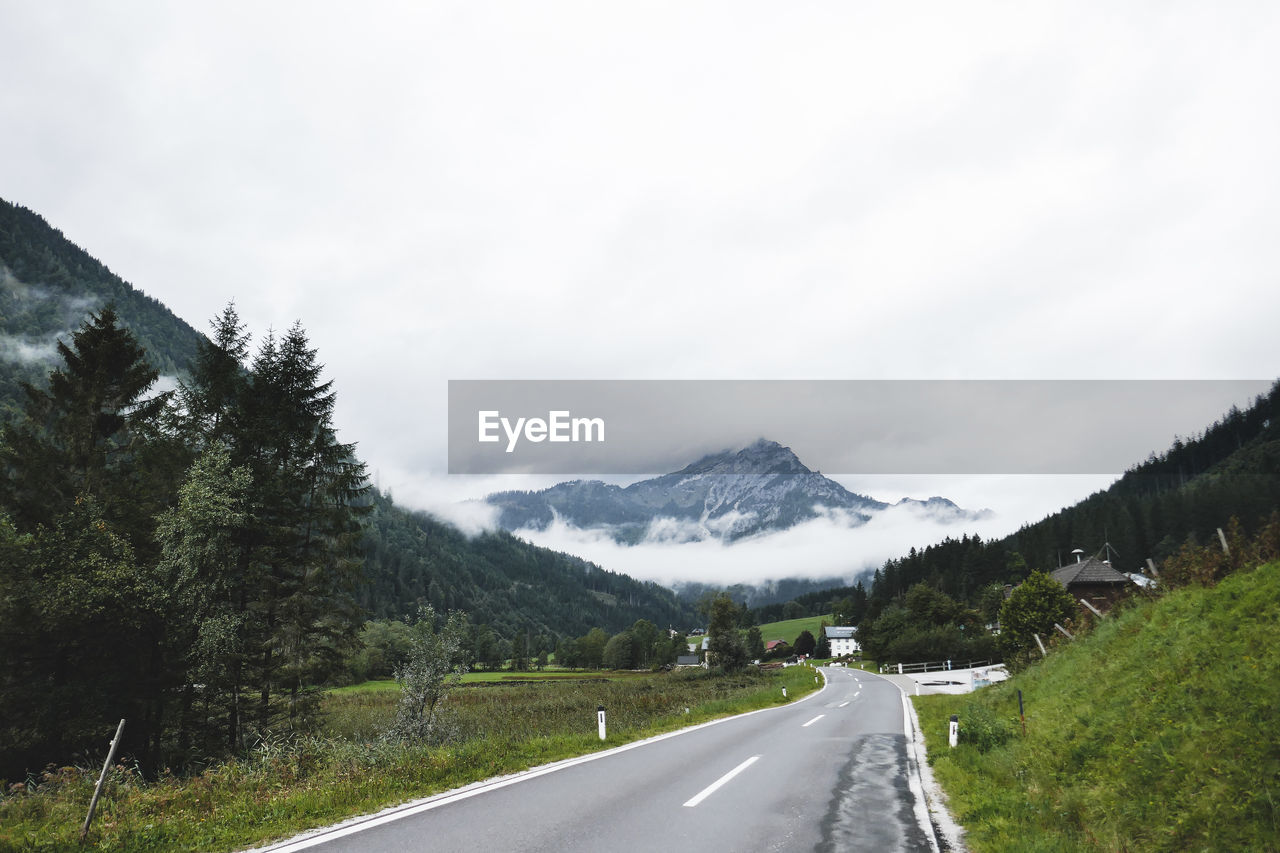 EMPTY ROAD ALONG MOUNTAIN RANGE AGAINST SKY