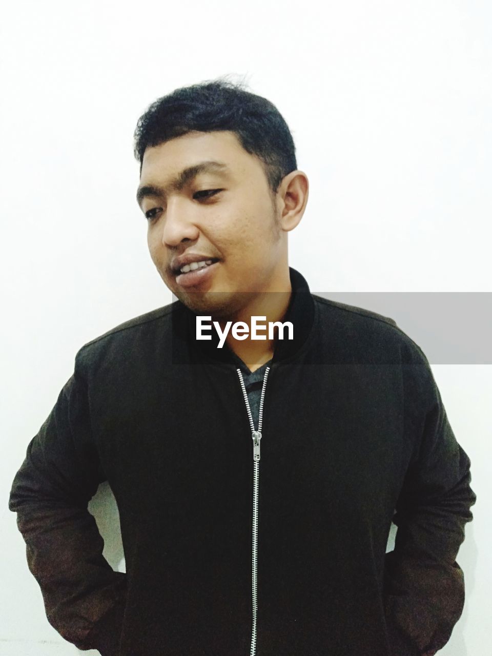 YOUNG MAN LOOKING AWAY OVER WHITE BACKGROUND