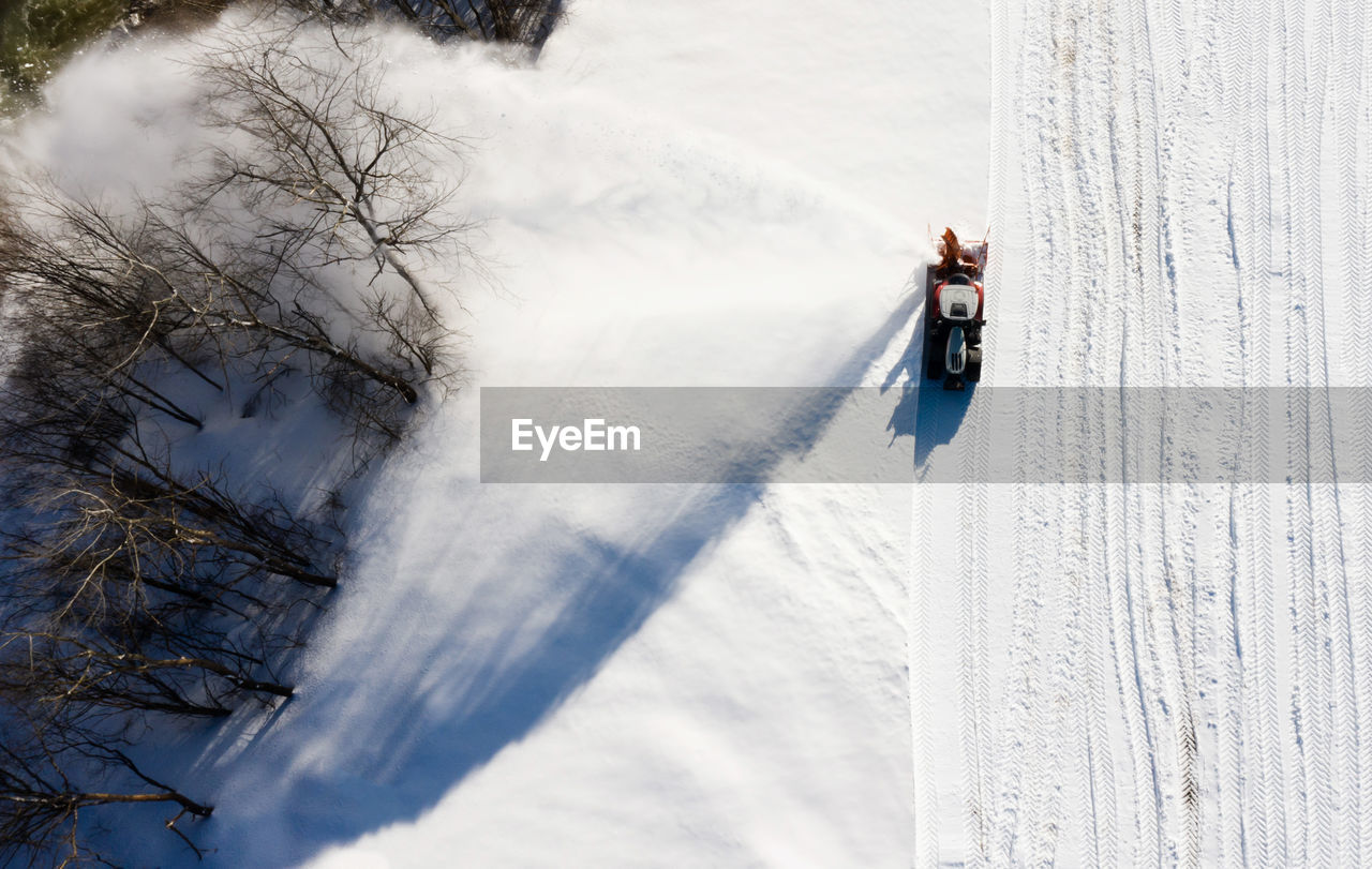 Snow thrower is cleaning the snow. birds eye view.