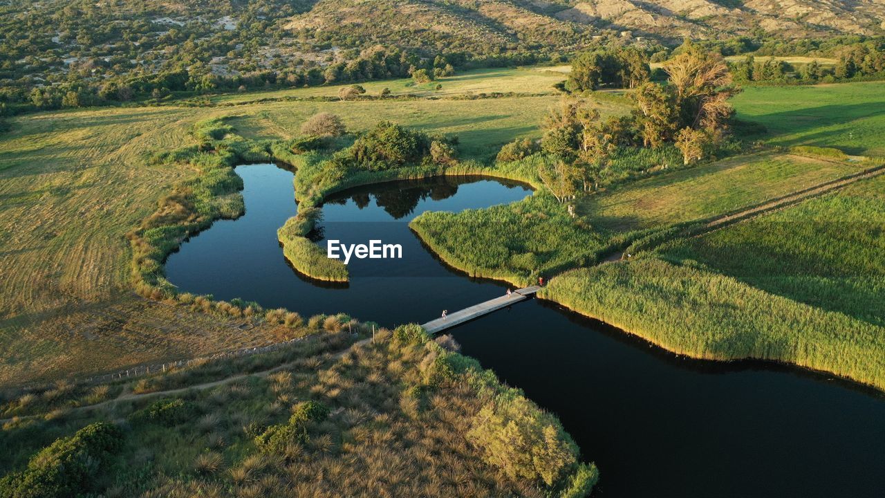 aerial photography, water, environment, landscape, scenics - nature, land, nature, beauty in nature, reservoir, green, plant, no people, tranquility, lake, aerial view, tranquil scene, rural scene, reflection, field, tree, non-urban scene, agriculture, day, outdoors, hill, high angle view, travel destinations, idyllic, travel, grass