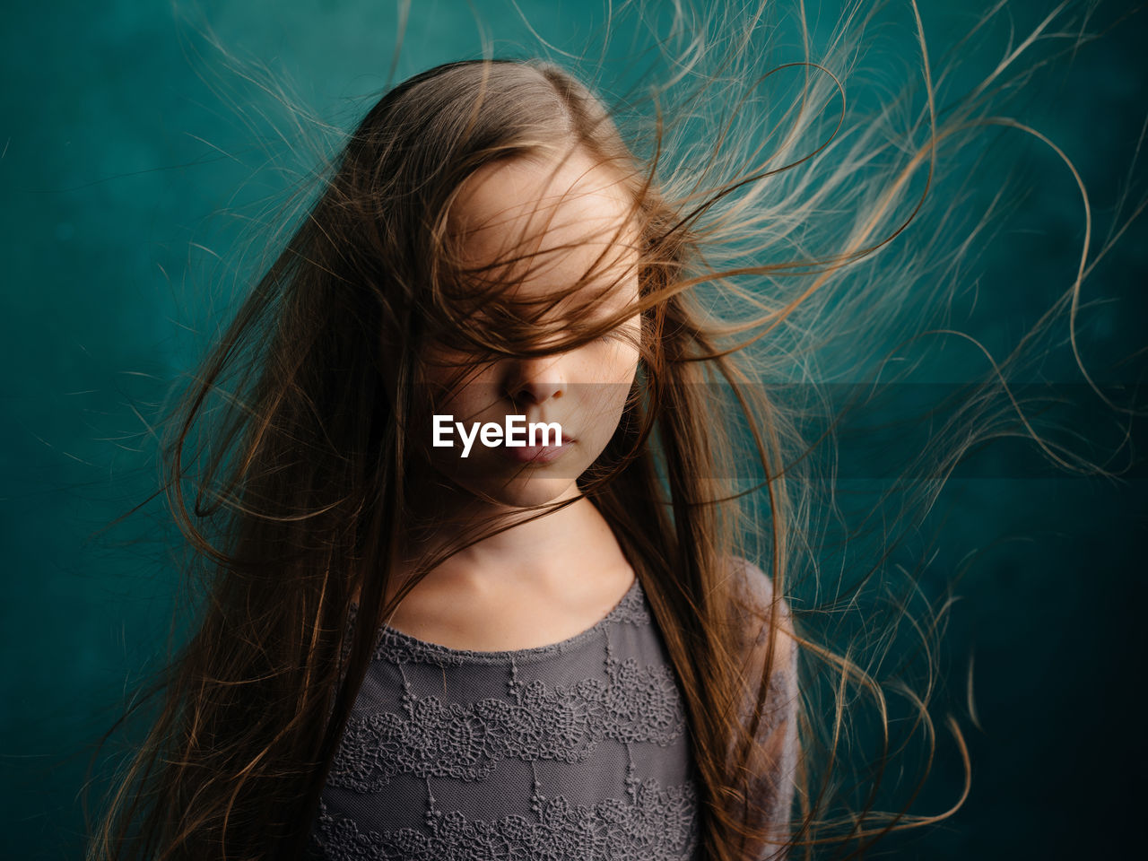 CLOSE-UP PORTRAIT OF A GIRL WITH HAIR IN BACKGROUND