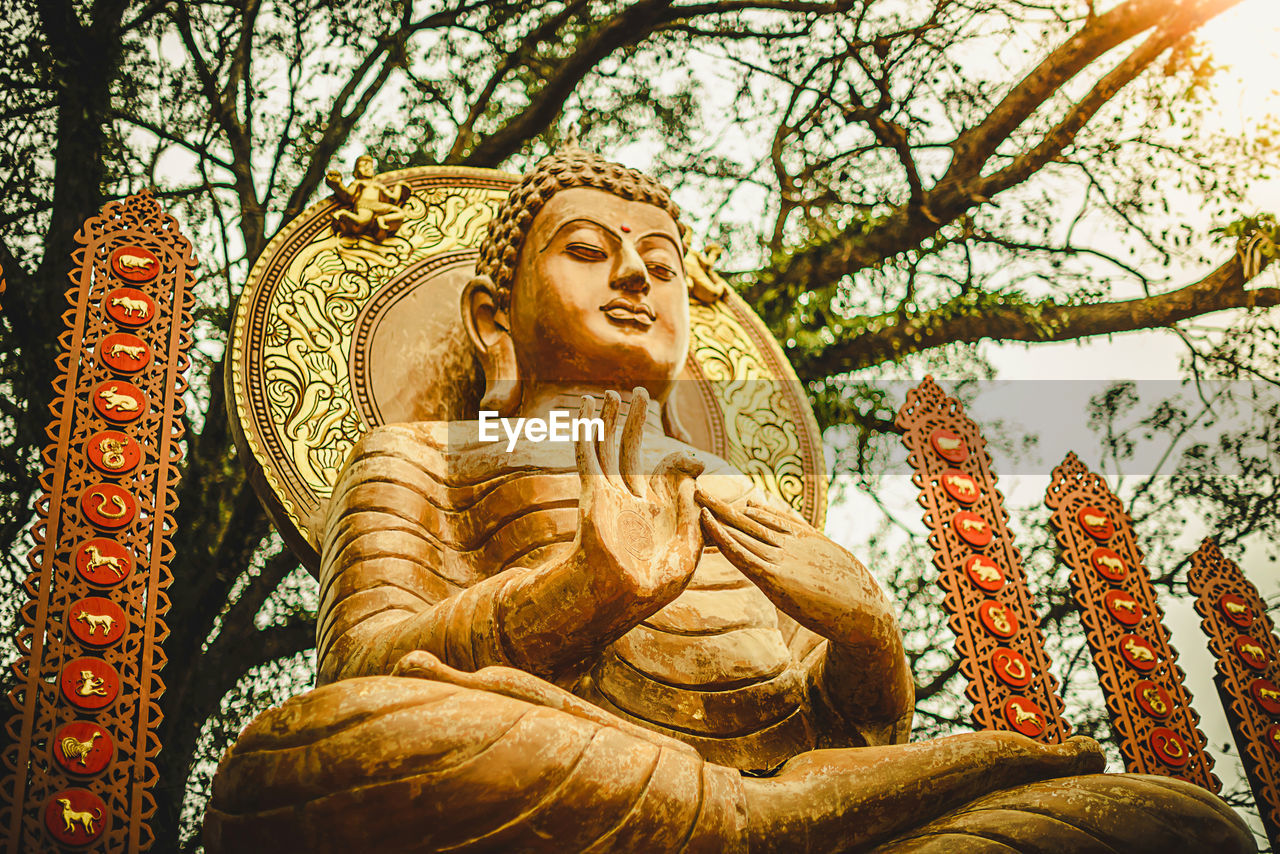 LOW ANGLE VIEW OF STATUE AGAINST TREES