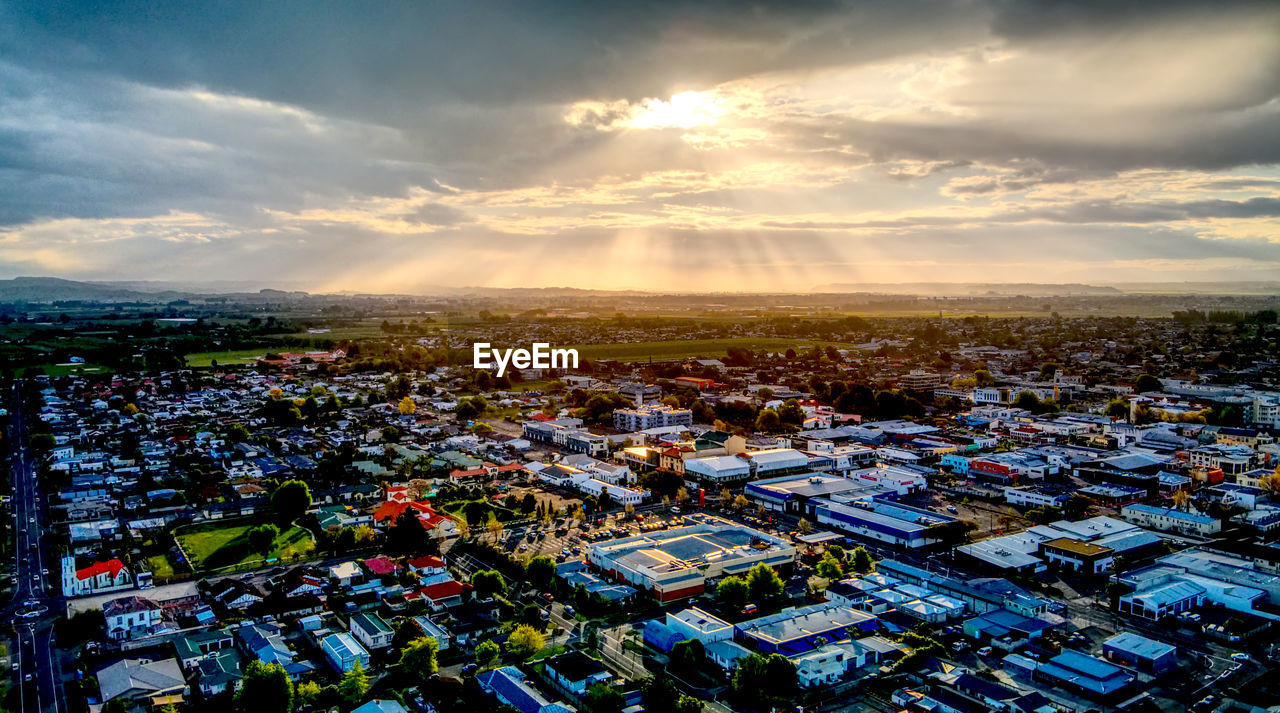 HIGH ANGLE SHOT OF TOWNSCAPE AGAINST SKY DURING SUNSET