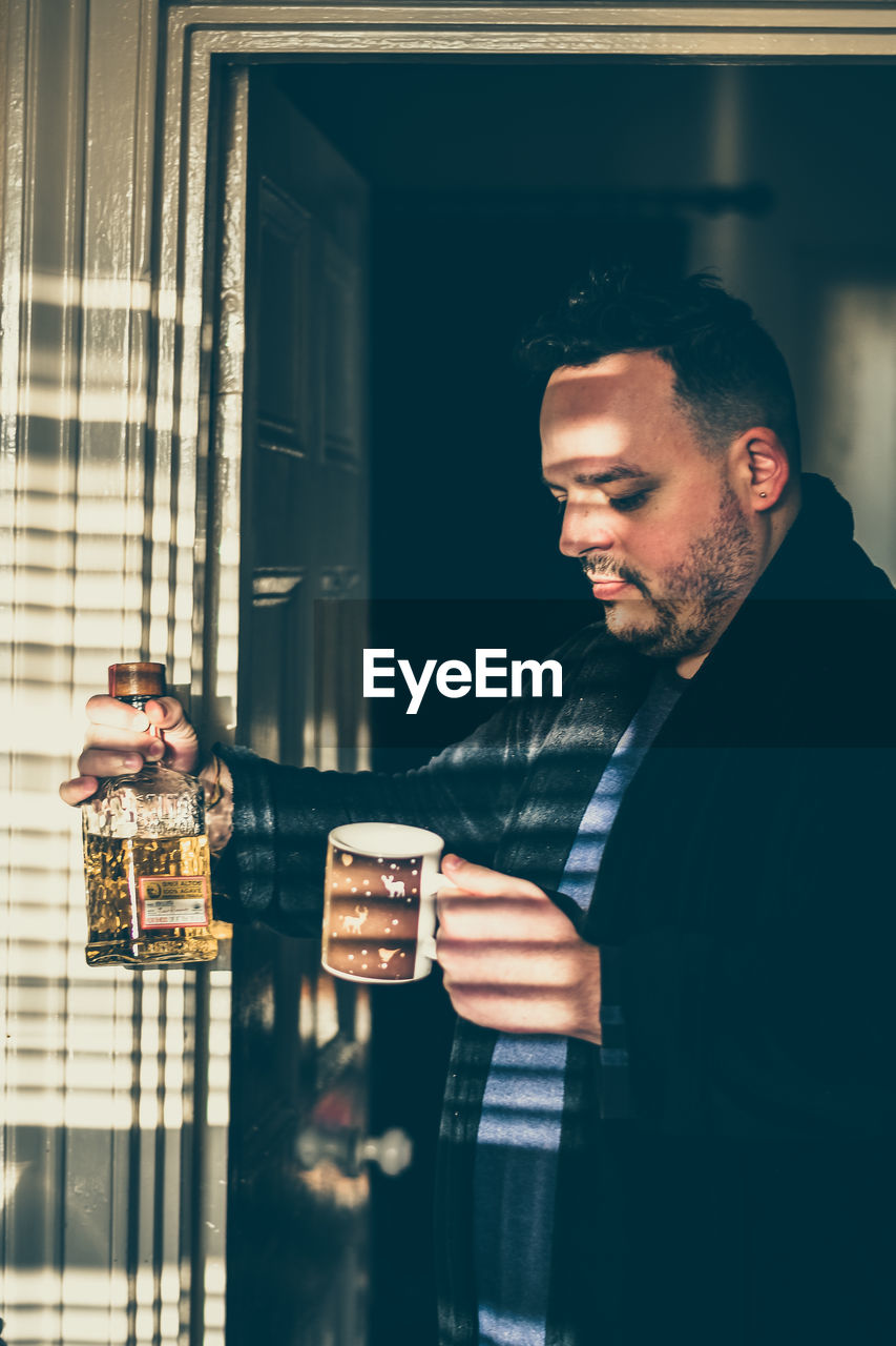 Portrait of a man choosing between coffe and alcohol 