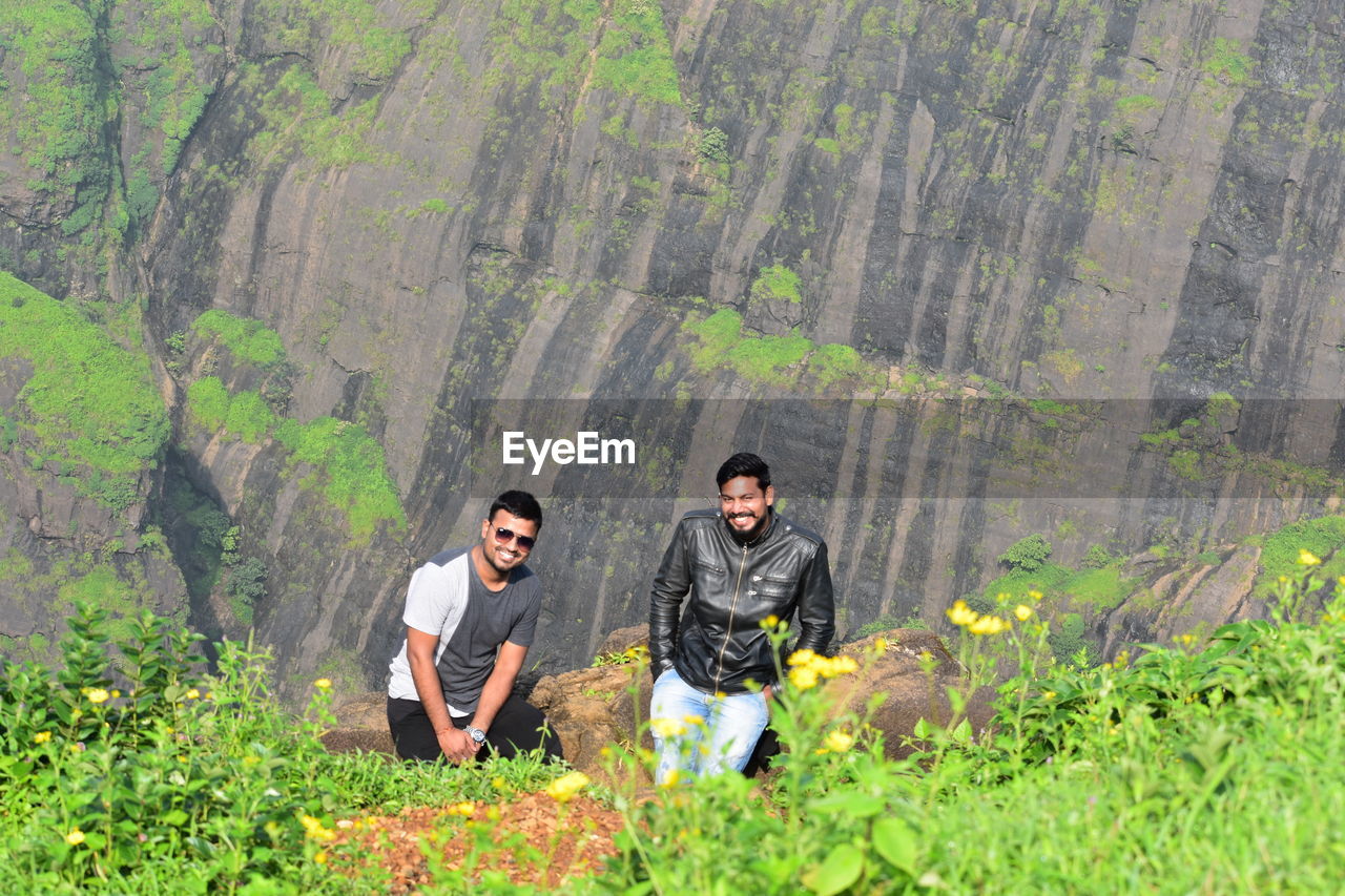 High angle view of smiling friends standing against mountain