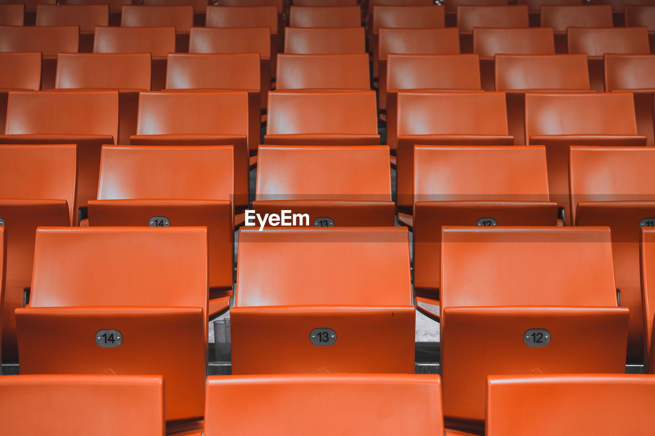 Full frame shot of empty orange chairs in stadium