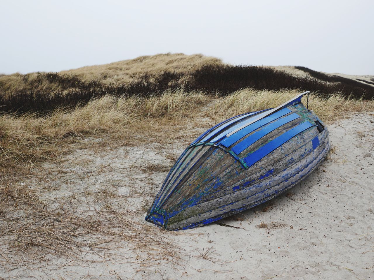 Blue boat moored at beach